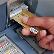 person using debit card at an ATM